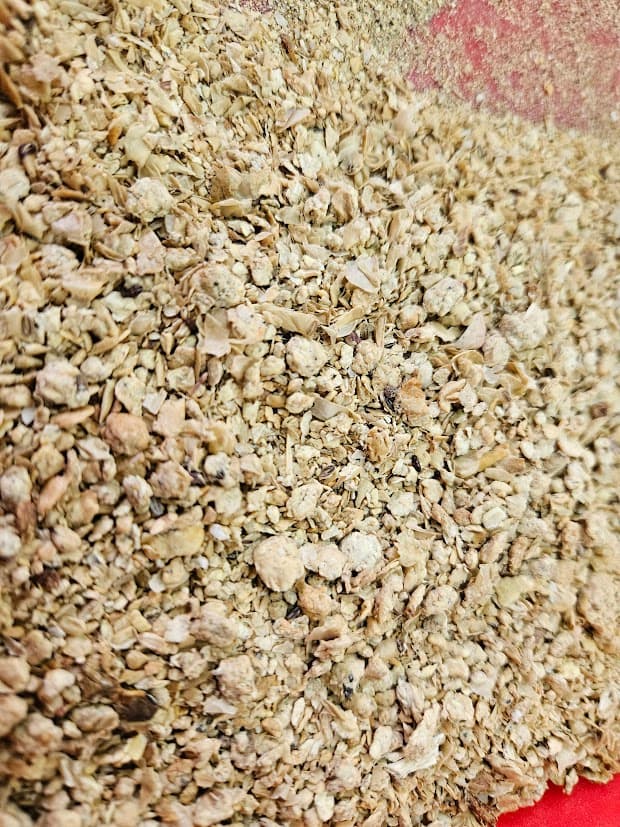 Soybean meal flakes being sampled at a feed mill