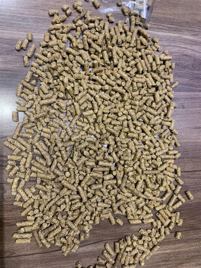 Close-up of calf starter feed pellets, 4 mm cylindrical extruded pellets in a brown colour