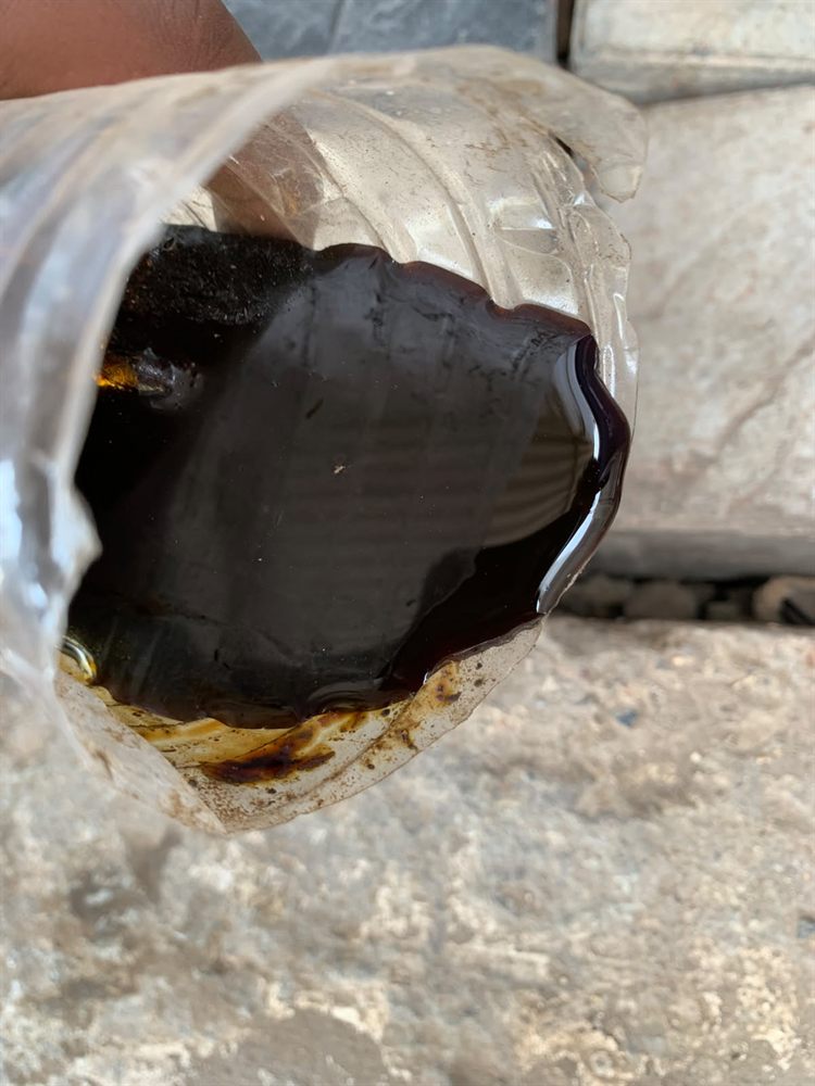 Sample of liquid molasses drawn from a tanker for receiving-dock quality check — dark colour, viscous consistency, and absence of fermentation bubbles are the visual tests every feed mill should run before accepting a load